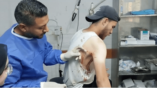 Abdel Karim Zouidi receives medical treatment for a shrapnel injury.