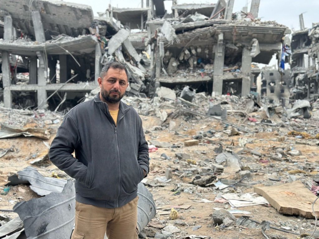 Mohammed Ahmed stands amid the ruins of a building after an airstrike