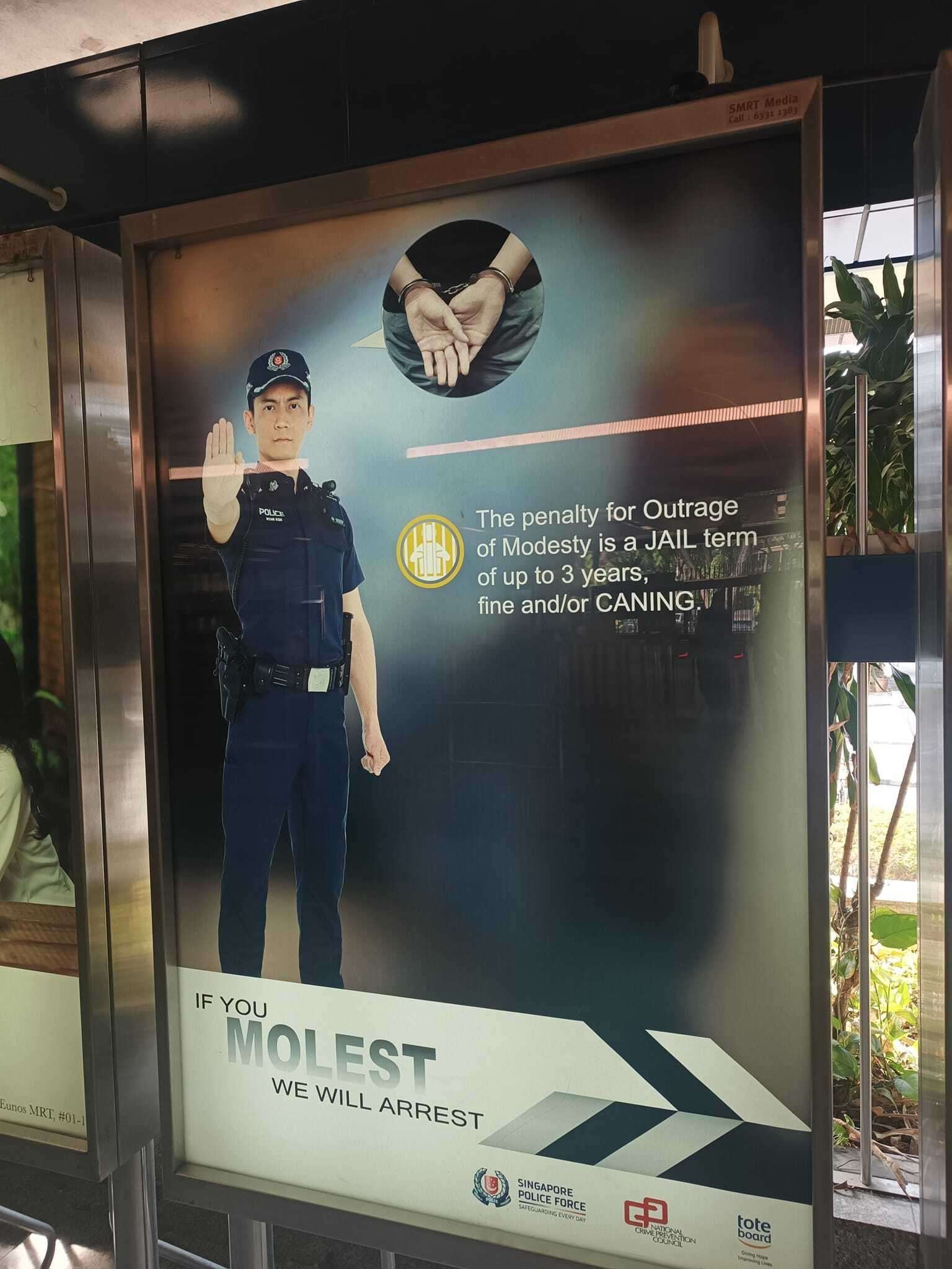 A sign with a police officer reading 'The penalty for outrage of modesty is a jail term up to 3 years, fine and/or caning. If you molest, we will arrest'