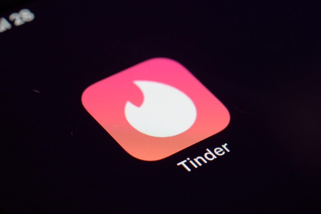 The Tinder logo displayed on a smartphone.