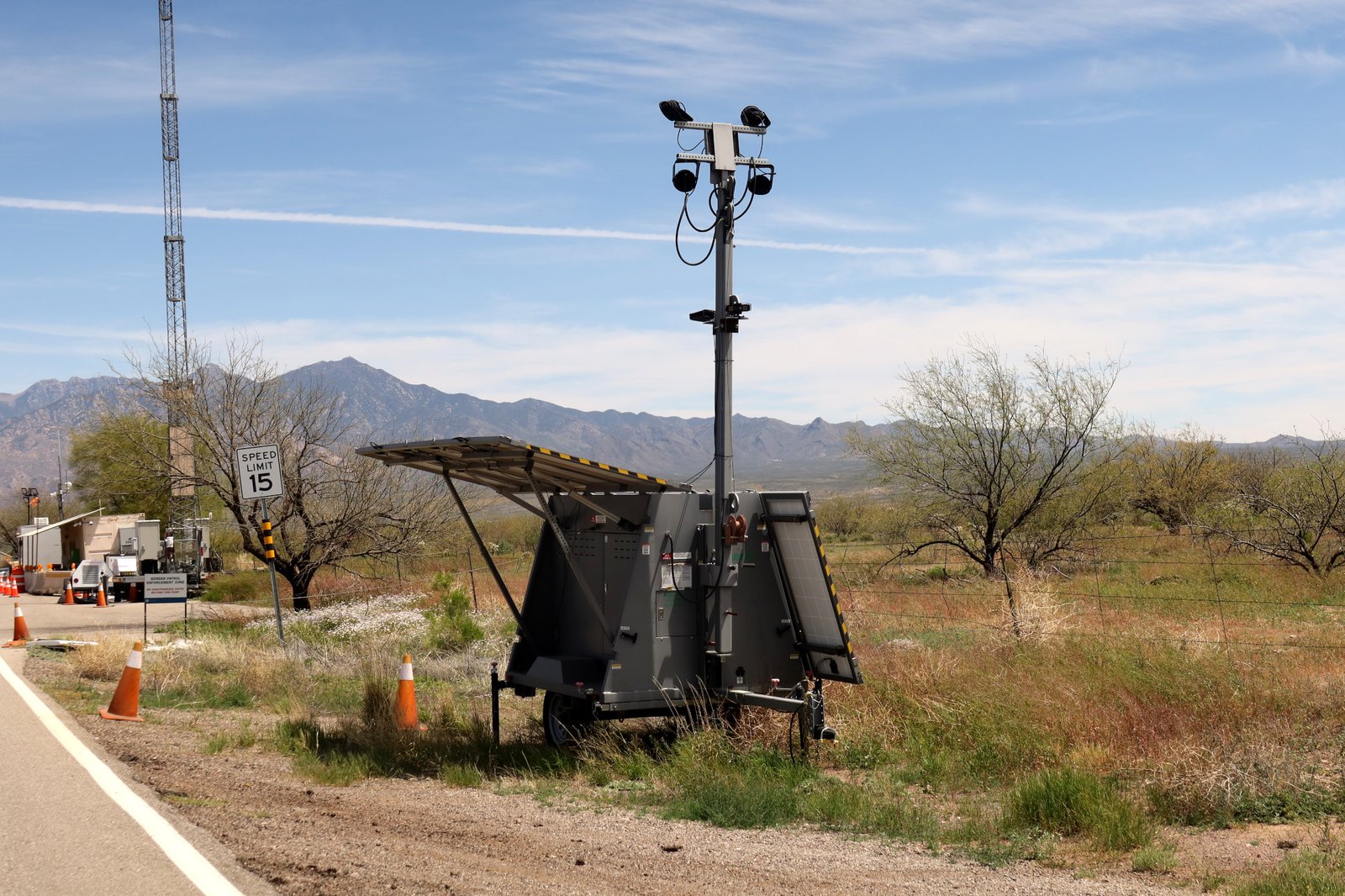 A trailer with a pole with mounted ALPR cameras in the desert.