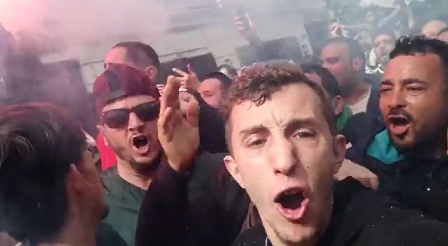 Tadjadit and others face the death sentence for their part in encouraging social media users to express discontent with the government through using the #ManichRadhi (I am not satisfied) hashtag

				
				
				
				
				This article first appeared in the Spring 2026 issue of Index on Censorship, The monster unleashed: How Hungary’s illliberal vision is seducing the Western world published on 2 April 2026. 
Algerian poet Mohamed Tadjadit, winner of the Index 2025 Freedom of Expression Award in Arts, was recently jailed following trumped-up charges. He is also facing separate charges that mean he could face the death penalty. [His trial is due to take place on 30 April 2026 and the UN has called for the charges to be quashed.]
Tadjadit writes raw poetry rooted in social reality and his poems have quickly become a popular expression of the anger, hope and dignity of a people striving for freedom against an authoritarian government.
He writes about the challenges facing Algerian youth: unemployment, marginalisation, lack of opportunities, bureaucracy, the state of the economy and social exclusion.
He was jailed by the authorities for his part in the Hirak movement – a series of peaceful protests which started in 2019 after then president Abdelaziz Bouteflika announced his intention to stand for a fifth term. After the protests erupted, Bouteflika resigned but his place was taken by former prime minister and ally Abdelmadjid Tebboune.
Under Tebboune, there has been escalating repression and the systematic criminalisation of all dissenting voices. Algeria faces one of the darkest periods in terms of freedoms and human rights since its independence.
Zaki Hannache, a member of the Anti-Repression Network, became involved with Tadjadit the year he was first arrested.
“I had been documenting arbitrary arrests linked to popular mobilisations since July 2019, which led me to follow his case closely from the start,” Hannache said. “I was present when Mohamed was apprehended following a peaceful sit-in in solidarity with prisoners of conscience in front of the Sidi M’hamed court.”
Hannache, who now acts as Tadjadit’s representative and manages his Facebook page, has been legally pursued and imprisoned for his work documenting human rights violations, particularly regarding prisoners of conscience.
Tadjadit was arrested immediately after the sit-in and has since become known as “the poet of the Hirak”.
Hannache told Index: “Mohamed’s poetry resonated widely because it is accessible, sincere and deeply rooted in social reality. Mohamed writes in Algerian darija, a simple, popular and easily understandable language. He addresses current events, the everyday experiences of citizens, their frustrations and aspirations.
His poems speak truths without filter, delivered through a courageous activist voice, while also incorporating historical references that strengthen their impact.
“Mohamed belongs to a generation that grew up just after the ‘black decade’, a dark period marked by violence and terrorism. He also lived under Abdelaziz Bouteflika’s 20-year governance, characterised by widespread corruption and chaotic administration. The sense of lacking real freedom despite the sacrifices of independence martyrs, the experience of oppression (hogra) and the political use of fear during the ‘black decade’ to suppress legitimate popular demands all profoundly shaped his poetic imagination.”
Over the past six years, Tadjadit has been in and out of court facing arbitrary legal proceedings. In early November, he was sentenced to five years in prison following trumped-up charges of “glorifying terrorism” and “using communication technologies to support terrorist organisations”. The sentence was reduced to one year on appeal.
In a separate case that month, he and 12 other activists were charged with “conspiring to incite citizens against the authority of the state and to undermine national unity” – a crime which carries the death sentence. That case has now been postponed to the next court session between March and June 2026.
Hannache said Tadjadit was deeply attached to Algeria’s history, particularly to the memory of the country’s national liberation war.
“He has always been close to people who lived through colonisation and the independence struggle, listening to their stories and sacrifices after 132 years of [French] colonial domination,” he said.
“This strong connection to collective memory and national identity largely explains his attraction to poetry, which he sees as a means of transmission, resistance and fidelity to the spirit of independence.”
Here we publish three of Tadjadit’s poems, translated into English for the first time.
Tadjadit recited the first poem in the early weeks of the Hirak movement.
“At that time, there was an open space in the streets of the capital dedicated to political debate and public exchange. Citizens, activists and artists gathered to speak freely, discuss the future of the country and express dissent,” said Hannache. “Videos of the recitation circulated extensively and [had] thousands of views.”

Untitled 1 By Mohamed Tadjadit
He who once presented himself as a leader has become someone who hides.
Abroad, he surrounded himself with walls,
forgetting that the people are the true elite
and that the fate of every decision belongs to them.
He who rode the wave did not do so out of love;
we know well the marks of the traitor.
This country is not a game,
it is the land of free men.
In our downfall, you were the cause;
there is no longer any dialogue with you.
My homeland is a land of men,
a land of desert and mountains,
a land of Revolution, a land of wealth, a land of struggle.
The garment of my country is tailored
from the fabric of freedom.
Its roots are Amazigh,
and its Arab identity is illuminated by Islam.
I will speak a little about its condition,
about this country shaped by time,
where free men were sold,
where the ignorant became rulers,
where everyone now sees it as their private property.
They imprisoned the people,
they deepened the injustice against them,
and freed only those who obeyed.
O my homeland, one can no longer even think clearly about you;
these are the children of your enemy, and they are hungry.
Even our rights have become illusions.
O my mother, your children are lost.
They locked us into a corridor of madness;
I speak to you with my soul, O my homeland.
By God, there is not a trace of manhood among them.
What kind of election is this,
when the people are not satisfied?
When the sun rose,
it burned through their sieve,
and their past was exposed to the light.
In any case,
the fourth-mandate-and-a-half will not pass as something ordinary.
My homeland is full of men:
sons of the sea, sons of the desert, sons of the mountains.
The people made the Revolution;
they plundered it – today, struggle is necessary.
Is it not true that Algeria is strong through its people?
Or has the national spirit itself begun to fade?
In summary,
we have broken the chains of slavery.
The second poem is part of a campaign which encouraged social media users to express discontent with the government through using the #ManichRadhi (I am not satisfied) hashtag. Tadjadit’s involvement is being used as evidence by prosecutors in the case for which he faces the death sentence.

Untitled 2 By Mohamed Tadjadit
Welcome to the new Algeria.
We have taken your concerns fully into account.
We will tell you about our achievements in a poem.
We have carried out great projects for you.
The country’s renaissance is not far away.
We have made our decision:
we will rebuild the Blida roundabout for you,
and you will experience innovation with us.
We only want what is useful for you.
You haven’t heard it on the news,
and you haven’t read it in the newspaper.
Soon the sea will dry up, and we will fill it with Saïda [a well-known brand of mineral water in Algeria].
And we will amaze you with our ideas.
And anyone who criticises us will face severe punishment.
Really “fighters”, really “revolutionaries”?
They have no shame and carry a stubborn pen.
They want us to build hospitals.
They lack faith and conviction.
Everyone knows we will die one day.
We have already outlined the main lines.
We will regulate prices.
The potato crisis? We have solved it.
And we have created for you the University of Hot Peppers.
We will export orange peels and use them for investment.
You went out into the streets for the Hirak,
but it is we who took control.
You wanted an independent judiciary,
and we have not forgotten that demand.
But after we first create the space taxis,
it is neither our concern nor in our hands.
We hold the seat of power,
and we are loyal to it.
Tadjadit continues to write from his cell in El Harrach prison, including the final poem printed here.
Hannache said: “Several have been released and widely circulated on social media, becoming symbols of resistance and dignity in the face of repression.”

Untitled 3 By Mohamed Tadjadit
The Hirak of the people draws,
each colour receives its words.
It draws minds on its land that work,
where every person has value and dignity.
And the country advances through knowledge,
these are not empty words.
It draws birds that do not suffer
and that achieve their dreams.
Children read and learn,
holding a raised flag in their hands,
with a smiling star and crescent,
living in peace.
It draws a strong and organised army,
where light overcomes darkness.
It draws the law that governs,
and justice that guides the decisions.
The executioner does not control;
under its wing, everyone serves,
fighting ignorance and injustice.
It draws them as twin brothers,
resisting for humanity.
It establishes order and draws
a generation that does not compromise,
with a vision for the future,
moving forward in the world’s politics,
impossible to be destructive.
It draws with art and the generosity of the pen,
always peaceful in its drawing.
It draws the street that speaks,
and freedom that resonates in its sounds.
It draws a spirit that does not surrender,
and which, with every step forward, grows stronger.
They tried to stop it from continuing to draw,
wanted to break its pencils,
to prevent it from dreaming,
and criminalise its thinking.
All poems translated by Zaki Hannache

			
			
					
				
				
				
				READ MORE