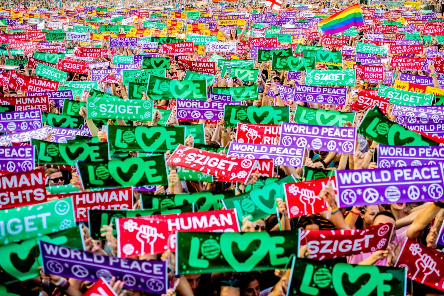 Hungary’s Sziget festival is known as a safe place to express yourself freely. Photo: Sandor Csudai/www.facebook.com/csudaisandor

				
				
				
				
				This article first appeared in the Spring 2026 issue of Index on Censorship, The monster unleashed: How Hungary’s illiberal vision is seducing the Western world published on 2 April 2026.
Crossing Budapest’s brutalist K-Bridge across the Danube to Óbuda Island on a grey spring day feels like the last journey of a condemned prisoner. The steel truss bridge was built as a temporary measure in 1955, a year before the uprising in which university students and ordinary citizens took to the streets to protest against the Stalinist government of Mátyás Rákosi. The single set of railway tracks suggests a one-way journey. It was built to give access to Budapest’s great Ganz Danubius shipyard. The shipyard was finally closed in 2000, after years of decline.
These days, the bridge acts more like a rabbit hole from Orbán’s Hungary into Wonderland. Every summer, hundreds of thousands of people young and old cross to the leafy island to be entertained by music, theatre and dance, and to be challenged by debate, art and film – the joyous week-long celebration of free expression that is the Sziget Festival.
Sziget was born from the ashes of Communism.
In 1993, four years after the fall of the Iron Curtain, Károly Gerendai was just 22.
Thin and sporting a shock of long hair like a Hungarian David Gilmour, Gerendai had become interested in the music industry whilst in high school. As a student, he earned money fly-posting and as a tour manager. Later, he managed bands and worked for record labels.
That year, he was in charge of Sziámi, one of the best-known alt-rock bands in the Hungarian underground scene. On the tour bus after a concert, he fell into conversation with Péter Müller, the band’s frontman.
“We talked about how, after the political transition, the big youth events had disappeared,” Gerendai told Index. “Before the political transition of 1989–90, there were state-organised youth events, but we quickly realised that they mainly served as a way for the state to control young people. Although we could meet and have fun together, we always felt the state’s watchful eye on us.” State control extended beyond the audience and on to the stage. “In the music industry, strong state selection was also in place: there were supported, tolerated, and banned bands, so not everyone was allowed to be heard.”
This is where the seed of something new was born.
Post Iron Curtain
Co-founder Károly Gerendai. Photo: Sziget Festival
“We thought it would be great to organise a multi-day event where young people could be together – something like a holiday combined with concerts, various cultural programmes, and community activities,” he said.
Gerendai and Müller approached Gábor Demszky, mayor of Budapest at the time and first of the post-Communist era, for help.
“He supported the concept but told us to organise it ourselves,” Gerendai told Index. “Even though we had no experience with anything like this, we boldly jumped into the organisation.”
This make-it-up-as-you-go-along approach was typical in post-Soviet eastern Europe.
The mayor suggested three possible venues for the festival, one of which was Óbuda Island. The island punctuates the Danube like a giant green exclamation mark between the city’s two halves, Buda and Pest.
“Two iconic music events had previously been held there, both attracting huge interest,” said Gerendai. “One was the 1980 Black Sheep concert, a rare occasion when both tolerated and banned bands were allowed to perform. Then in 1991, it was one of the venues for the ‘Goodbye, Ivan!’ event celebrating the withdrawal of Soviet troops. I had worked on that event, which is how I got to know the subcontractors we later invited to help organise our festival.”
Hungary’s youth were ready for a party. After only a few months’ preparation, the festival – initially called Diáksziget, Student Island in Hungarian – attracted 43,000 visitors over seven days.
“We organised the first festival with the slogan ‘We need a week together’, referring to a carefree, shared community experience. Another slogan was ‘Everything is allowed, but nothing is mandatory’, which was meant to help us leave the past behind, celebrate freedom in every sense, and express that we never again wanted to live in a dictatorship,” said Gerendai.
A wobbly start
The line-up for the first festival was largely made up of Hungarian artists, such as alt-rock band Kispál és a Borz, punk band Tankcsapda, and singer János Bródy. In all, 200 bands performed on the festival’s two stages, alongside open-air movies and theatre productions.
Yet, as was often the case after the fall of Communism, things didn’t work out as planned. Despite receiving sponsorship from Pepsi, the country’s Nagykanizsa brewery, and some support from the city of Budapest, the festival lost money. Lots of it.
“It didn’t go smoothly,” admitted Gerendai. “We faced numerous problems during the process and made serious financial miscalculations.”
By the end of the festival, it had run up a huge deficit, and only survived thanks to a bailout by the city council. But after this first turbulent year, Sziget not only survived but thrived.
The following year saw the number of festivalgoers – or Szitizens as they are usually known – increase to 143,000. International acts like Jethro Tull, The Birds, and Jefferson Starship started to appear on the line-up.
“Sziget outgrew Hungary’s borders early on, and we consciously developed the programme lineup, services, and visual identity so that we would be seen as a unique festival on the international scene as well,” said Gerendai.
A beacon of light
Chappell Roan on stage at Sziget. Photo: Sziget Festival
By 2019, the festival was attracting more than half a million visitors to the Hungarian capital every year. The festival’s reputation was such that it was bringing in some of the world’s biggest music acts, including Arctic Monkeys, Kendrick Lamar, Kings of Leon, P!nk, Rihanna, Muse and David Guetta.
Óbuda Island has remained the home of the festival. “It’s a great location: close to downtown Budapest, yet also a green, nature-filled area. It’s also symbolic – an island surrounded by a river, where once you cross the bridge, you can leave everyday problems behind,” Gerendai told Index. “It’s the origin of the nickname given by visitors: the Island of Freedom.”
This nickname comes from the festival’s commitment to allowing artists and festival goers to speak their views – and was easy to pull off in a liberal city like Budapest keen to attract to hordes of young foreign tourists to boost the economy.
In Gerendai’s opinion, freedom of expression was one of the major achievements of Hungary’s political transition in the 1990s. “I believe freedom of expression is a broader concept than simply who we agree or disagree with; it’s not fundamentally our role to judge other people’s views. At Sziget, we have always provided space for differences of opinion and we respect artistic freedom of expression on stage as well. At the same time, we do set limits: we do not allow hate-inciting or human-dignity violating expressions, and we also do not give space to extremist productions whose audiences could potentially endanger the safety of festival visitors.”
As well as music, the festival is a thriving forum for circus, street theatre, film, visual arts and cabaret. At the heart of the festival is an area called Think for Tomorrow. The zone addresses pressing social issues that have an impact on the lives of young people, from their own perspective.
“NGOs and organisations that play an important role in social and cultural life have also had their own dedicated space at Sziget since the early days,” said Gerendai. “These groups are worth introducing to the festival audience, and their work aligns with Sziget’s core values, such as sustainability, the protection of human rights, and acceptance.”
Stepping back
Magic Mirror at Sziget. Photo: Kristóf Hölvényi /Rockstar Photographers www.instagram.com/kristofholvenyi/
Eight years ago, after running 25 Sziget festivals, Gerendai decided to step back and sell his interest in the festival to promoter Superstruct, owned by American private equity company KKR.
“I decided to pass the baton and from then on followed the festival only as a guest,” he said.
During his time at its helm, the values of the Sziget festival had grown increasingly at odds with those of Viktor Orbán’s Fidesz government.
There is a huge LGBTQ+ presence at Sziget, both in visitors and artists, with the Magic Mirror venue on the site hosting themed content exploring the LGBTQ+ experience.
After the Orbán government introduced anti-LGBTQ+ legislation in 2021, the festival’s new organisers came under pressure over its stance, and there were calls for them to ban under-18s from Magic Mirror. The organisers refused.
Sziget’s audience has made itself heard on [former Hungarian prime minister] Orbán over the past few years.
At the 2023 festival, during Hungarian rapper Krúbi’s performance the audience started chanting Mocskos Fidesz (Filthy Fidesz). This chant has since become popular common at the festival and at other music events.
The Kneecap ban
Friction between the festival and Orbán burst into the open in 2025 after Irish rappers Kneecap, who were due to perform at the festival that summer, were banned from the country for being a national security threat. Kneecap are outspoken critics of right-wing political ideology and are particularly scathing about the Israel-Gaza War. Kneecap (along with Bob Vylan) had performed inflammatory sets at Glastonbury the month before and Orbán, for his part, has been strengthening his strategic alliance with Israel, going so far as to declare that “Jewish communities are safer in Budapest than anywhere else in Europe”.
Orbán told state broadcaster Kossuth Radio that he was angry that the band had been invited to play at Sziget. He claimed that the organisers’ decision was motivated by financial gain.
“Is this damn money really that important?” Orbán asked the radio presenter.
Even though they were unable to perform, Kneecap shared a message with festivalgoers gathering at the stage on which they were due to perform.
The message read: “We wish we could be there with you at one of the best festivals in the world and the first European festival Kneecap ever played,” the message read. “We can’t because of one hate filled man. Viktor Orbán.”
When this part of the message was displayed, a huge crowd who had been told on social media to expect something from the band started booing and chanting “Fuck Orbán”.
The message continued: “We have been convicted of zero crimes in any country ever. But we will call out oppression. For calling out Israel’s genocidal campaign Viktor has banned us from your beautiful country for three years. Israel is committing a genocide against the Palestinian people. Viktor Orbán and his government support it. Viktor Orbán and his government tried to shut down Pride in Budapest. They failed. We must stand together. Oppose Orbán. Oppose Israel. Oppose genocide.”
The festival’s robust stance in favour of LGBTQ+ rights has won it the European Festival Awards Take a Stand prize twice, in 2023 and 2026 (for 2025). The award recognises festivals that stand up for peaceful dialogue, humanism, tolerance, and mutual understanding – activities that do not necessarily chime with the profit imperative.
Stepping forward again
It is true, though, that since the Covid pandemic money has been a big problem for the Sziget festival.
Like many other European music festivals, Sziget had struggled thanks to two years of cancellations, the spiralling cost of living, and sharply rising artist fees. The festival lost .6 million in 2023, and almost  million in 2024.
In 2025, the company running the festival (without Gerendai) sent a letter to Budapest mayor Gergely Karácsony calling for the agreement between the festival and the city, as the island’s landowner, to be terminated.
The festival seemed to be doomed. But the return of a familiar figure saved it at the last minute – its co-founder, Gerendai.
“The new owner decided that they no longer wished to finance the festival, which had found itself in a difficult situation in the post-pandemic years due to economic conditions and, in my view, certain conceptual decisions as well,” said Gerendai. “They offered that if I took Sziget back, we could continue organising it under my leadership. So it was either I return – or there would be no Sziget.”
“It caused me several sleepless nights, since in the meantime I had been working on completely different things,” Gerendai told Index. “But in the end, I felt that a festival that has become a cultural institution in Hungary and is also significant on the international scene simply cannot end abruptly. Besides, this is my child – I couldn’t abandon it.”
Superstruct has come under huge pressure from activists and artists since its acquisition by KKR in June 2024. KKR has significant investments in Israeli companies, including some operating in the West Bank. In May 2025, a number of artists pulled out of the UK’s Field Day festival because of its Superstruct ownership.
The transfer of the licence from Superstruct back to Gerendai almost didn’t happen. Budapest City Council initially blocked the transfer, with councillors from Fidesz and Péter Magyar’s opposition Tisza party abstaining from the vote.
However, Hungary’s Index newspaper reports that Magyar, reacting to negative sentiment from potential voters over the news that Sziget might fold, quickly arranged a meeting with Gerendai. On 30 October, Magyar posted a picture of himself and Gerendai on Facebook, announcing that the pair would meet again at the 2026 festival after agreeing on two amendments to the proposals: first, that the costs of using the island would be paid back to the city by 2030 rather than 2035, and second, that all Hungarians under the age of 25 would get discounted tickets to the festival – a potential vote-winner among this demographic. Gerendai himself won’t be drawn on his politics.
The 2026 Sziget festival is now set to go ahead from 11 to 15 August 2026, featuring Florence + The Machine, Lewis Capaldi, Sombr, Twenty One Pilots, Biffy Clyro and Underworld as well as hundreds of others including Hungarian rapper Sisi on the line-up.
Gerendai said, “Many large music festivals operate primarily as business ventures focused on who is performing. In recent years, Sziget had also started to move in this direction, but I believe a festival should stand for more than that. Cultural diversity must be emphasised, as well as a commitment to core values. Reaffirming this ambition can be the key to long-term success – and this is what we aim for in the future.”
The future for music festivals remains uncertain but, for now, the legendary island of freedom looks safe back in Gerendai’s hands.

			
			
					
				
				
				
				READ MORE
