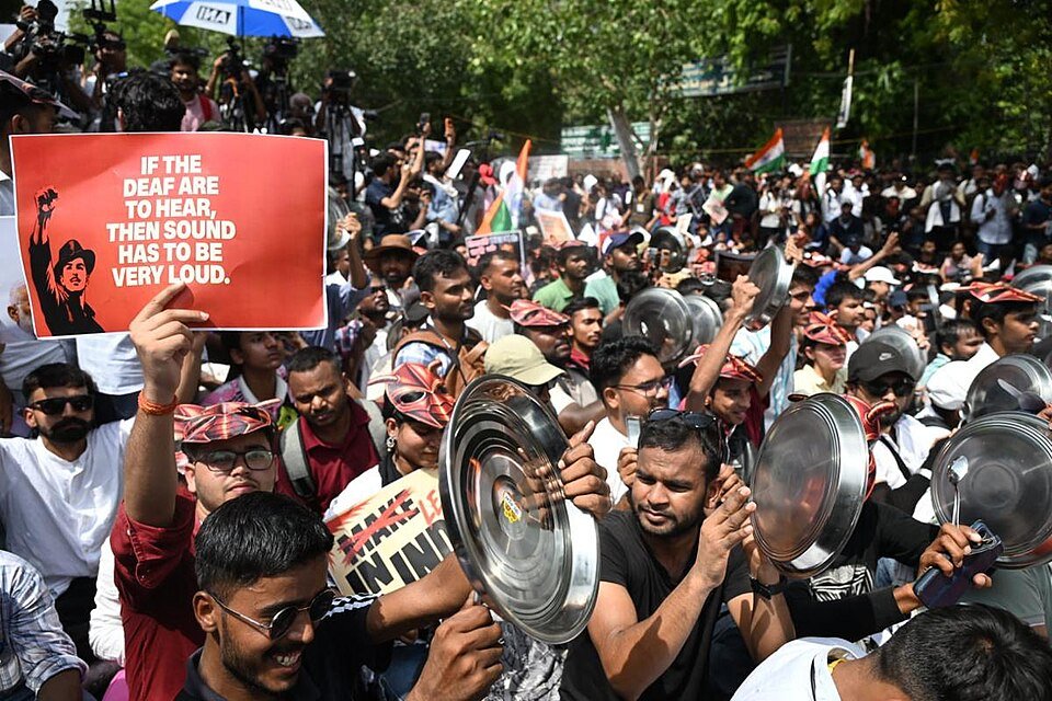 Cockroach Janta Party protestors holding posters of Bhagat Singh at Jantar Mantar, July 2026. Photo: Pelph Hoters/CC0 1.0
Towards the end of last year, when I was editing our magazine about Gen Z revolts around the world, I asked around about India. Was a Gen Z revolt likely there? After all, young people had toppled governments in neighbouring Bangladesh, Sri Lanka and Nepal. The consensus was that despite the increasing authoritarianism of Prime Minister Narendra Modi and his government, India was on a different trajectory to its much smaller neighbours. The young middle class were largely apolitical. Earlier protests had simply “petered out” because the country was so diverse no one could agree with one another.
Eight months later, it turns out there is something which unites young people – the understanding that they are despised by the political elites. The Cockroach Janta Party was formed after a satirical call on social media by student Abhijeet Dipke, a recent graduate from a US university who heard the chief justice of India comparing young unemployed people to “parasites” and “cockroaches”. What would happen, he wrote on Instagram, if all cockroaches came together?
It was a call that resonated. Within days of being formed the party’s Instagram account had 22 million followers – far more than the nine million following Modi’s BJP.
The authorities tried to strangle the movement at birth, and the Cockroach Janta Party‘s X account was closed down pretty quickly by Elon Musk’s platform after anonymous complaints. But that didn’t stop the momentum and soon the anger was focused on the leak of medical exam questions, meaning millions would have to do expensive retakes. The issue was emblematic of wider problems of graduate unemployment reported to be at 40% for under 25s. In the last week we have seen thousands of Gen Z demonstrators taking to the streets calling for the resignation of Union Education Minister Dharmendra Pradhan. Even the India opposition leader Rahul Gandhi (who has not been popular with young people) has tried to get in on the act and was briefly arrested after joining a sit-in in Delhi.
Other disturbing responses have included violence used against some protesters, the prohibition of protests near the parliament building in Delhi and the use of internet shutdowns being deployed in areas where demonstrations were planned to start on Monday.
Internet freedom campaigners in India, including the Software Freedom Law Centre (SFLC), have condemned the targeting of the protest with an internet shutdown as setting “a dangerous precedent” as it “strikes at the heart of the fundamental right to freedom of speech and expression”. They also are demanding to know why no order was issued to authorise the blackout, seemingly in violation of the law and not in accordance with the Supreme Court’s ruling on this issue. India has long turned to internet shutdowns for the flimsiest of excuses. According to Access Now India was the world leader for shutting down the internet for six years in a row ending in 2023 (ahead of places like Iran, Russia and Myanmar). The SFLC warn that together with reports of social media content about the protest being “shadow banned”, as well as the closure of roads and metro stations, the government seems to be trying to disrupt protest rather than guarantee public safety.
None of this is deterring Cockroach Janta Party supporters. If anything, it seems to be encouraging protesters to turn out. And the party’s popularity carries with it a message; globally connected young people are coming together and they are forces to be reckoned with.
READ MORE Cockroach Janta Party protestors holding posters of Bhagat Singh at Jantar Mantar, July 2026. Photo: Pelph Hoters/CC0 1.0
Towards the end of last year, when I was editing our magazine about Gen Z revolts around the world, I asked around about India. Was a Gen Z revolt likely there? After all, young people had toppled governments in neighbouring Bangladesh, Sri Lanka and Nepal. The consensus was that despite the increasing authoritarianism of Prime Minister Narendra Modi and his government, India was on a different trajectory to its much smaller neighbours. The young middle class were largely apolitical. Earlier protests had simply “petered out” because the country was so diverse no one could agree with one another.
Eight months later, it turns out there is something which unites young people – the understanding that they are despised by the political elites. The Cockroach Janta Party was formed after a satirical call on social media by student Abhijeet Dipke, a recent graduate from a US university who heard the chief justice of India comparing young unemployed people to “parasites” and “cockroaches”. What would happen, he wrote on Instagram, if all cockroaches came together?
It was a call that resonated. Within days of being formed the party’s Instagram account had 22 million followers – far more than the nine million following Modi’s BJP.
The authorities tried to strangle the movement at birth, and the Cockroach Janta Party‘s X account was closed down pretty quickly by Elon Musk’s platform after anonymous complaints. But that didn’t stop the momentum and soon the anger was focused on the leak of medical exam questions, meaning millions would have to do expensive retakes. The issue was emblematic of wider problems of graduate unemployment reported to be at 40% for under 25s. In the last week we have seen thousands of Gen Z demonstrators taking to the streets calling for the resignation of Union Education Minister Dharmendra Pradhan. Even the India opposition leader Rahul Gandhi (who has not been popular with young people) has tried to get in on the act and was briefly arrested after joining a sit-in in Delhi.
Other disturbing responses have included violence used against some protesters, the prohibition of protests near the parliament building in Delhi and the use of internet shutdowns being deployed in areas where demonstrations were planned to start on Monday.
Internet freedom campaigners in India, including the Software Freedom Law Centre (SFLC), have condemned the targeting of the protest with an internet shutdown as setting “a dangerous precedent” as it “strikes at the heart of the fundamental right to freedom of speech and expression”. They also are demanding to know why no order was issued to authorise the blackout, seemingly in violation of the law and not in accordance with the Supreme Court’s ruling on this issue. India has long turned to internet shutdowns for the flimsiest of excuses. According to Access Now India was the world leader for shutting down the internet for six years in a row ending in 2023 (ahead of places like Iran, Russia and Myanmar). The SFLC warn that together with reports of social media content about the protest being “shadow banned”, as well as the closure of roads and metro stations, the government seems to be trying to disrupt protest rather than guarantee public safety.
None of this is deterring Cockroach Janta Party supporters. If anything, it seems to be encouraging protesters to turn out. And the party’s popularity carries with it a message; globally connected young people are coming together and they are forces to be reckoned with.
READ MORE